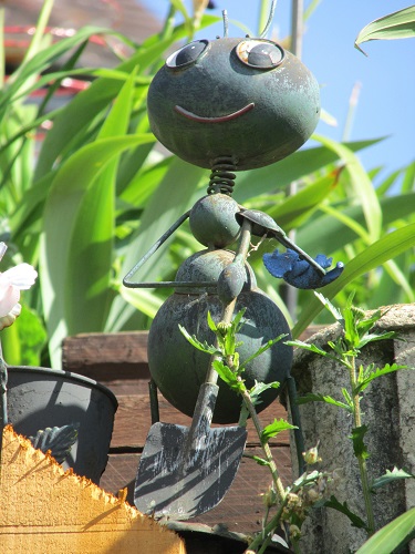 A metal model of a bug holding a shovel