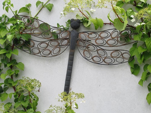 A metal dragonfly model on a wall