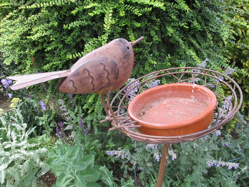 A metal robin model perched on a feeding station