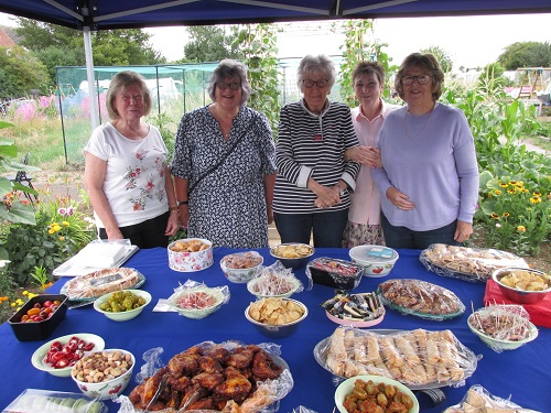 Garden party - our lady organisers pose behind a table of laid out food